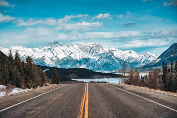 A road leading towards a snow-covered mountain range